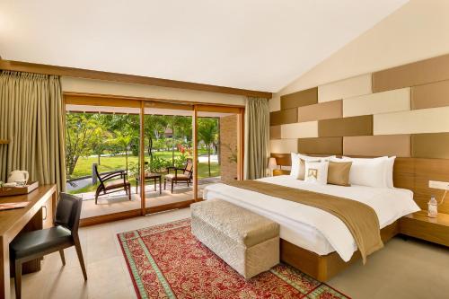 a bedroom with a large bed and a balcony at Welcomhotel by ITC Hotels, Kences Palm Beach, Mamallapuram in Mahabalipuram