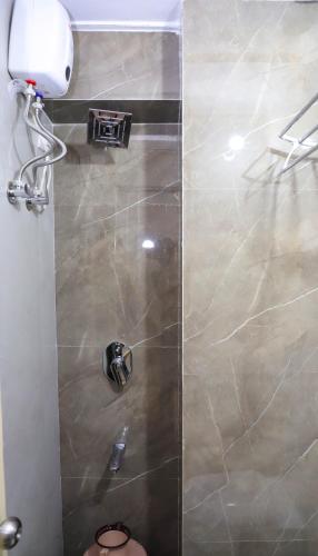 a shower with a glass door in a bathroom at Mithila Dormitory in Navi Mumbai