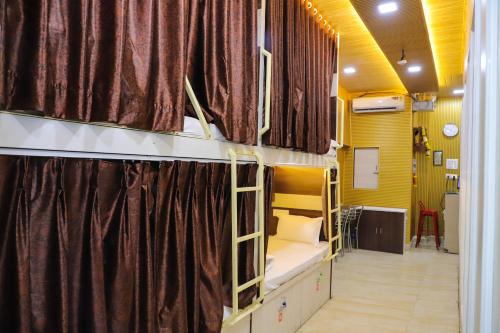 a room with two bunk beds and curtains at Mithila Dormitory in Navi Mumbai