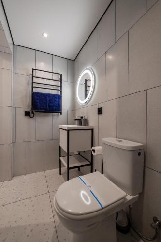 ein Badezimmer mit weißer Toilette und Waschbecken in der Unterkunft N17 Hotel in Poltawa