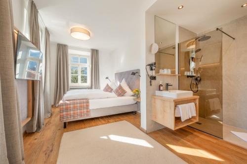 a bedroom with a bed and a sink and a shower at Gasthof-Hotel Dannerwirt in Flintsbach