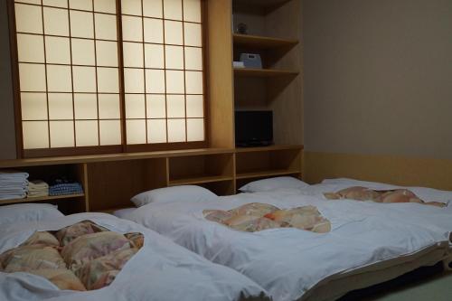two twin beds in a room with at Annex Katsutaro Ryokan in Tokyo