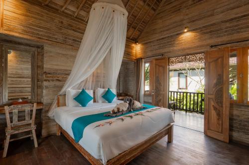a bedroom with a bed with a canopy at D'Gume Villas Lembongan in Nusa Lembongan