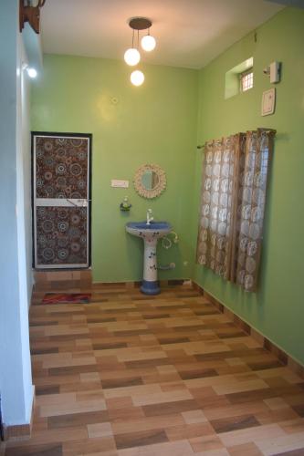 a bathroom with a sink and green walls at The Prem Vatika Homestay Maihar in Maihar
