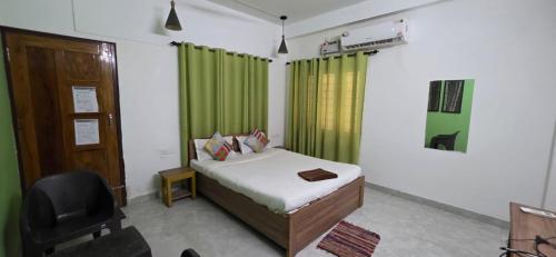 a bedroom with a bed and a green curtain at Hottel! Basera in Bhubaneshwar