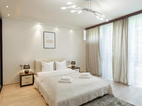 a bedroom with a large bed with two towels on it at Urban Chic - One Bedroom Apartment -Luxury Warsaw Stays - Grzybowska 5 in Warsaw
