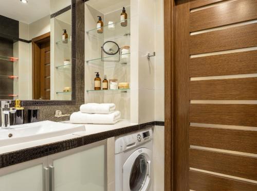 a bathroom with a washing machine and a sink at Urban Chic - One Bedroom Apartment -Luxury Warsaw Stays - Grzybowska 5 in Warsaw