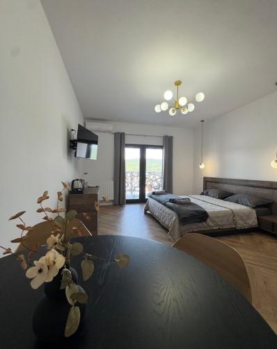 a large bedroom with a bed and a table at Pensiunea EUPHORIA in Sviniţa