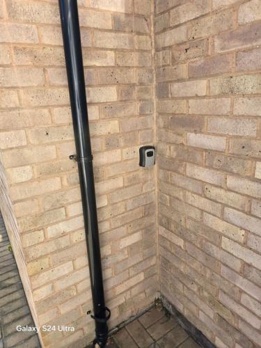a shower with a black pipe in a brick wall at Best room in Birmingham