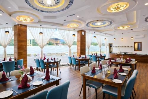 ein Restaurant mit Holztischen und blauen Stühlen in der Unterkunft Hotel HTC , Thimphu in Thimphu