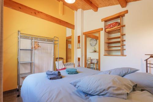 a bedroom with two beds and a clock on the wall at Gite Du Mouredon in Vallon-Pont-dʼArc