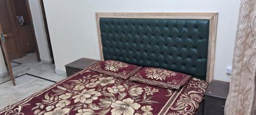 a bedroom with a bed with a green headboard at Sewa Kunj in Mussoorie