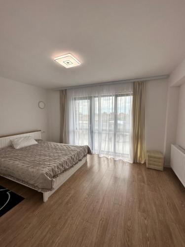a bedroom with a bed and a large window at Hotel Class in Oradea