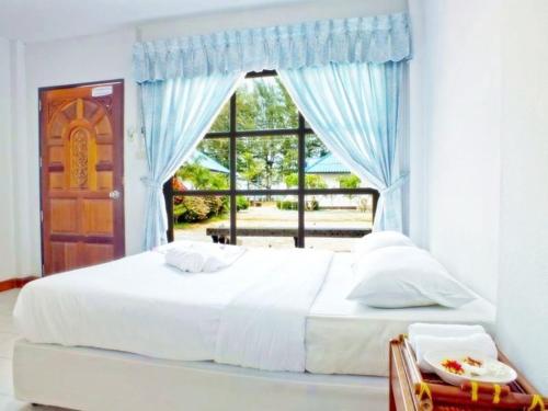 um quarto com uma cama branca e uma janela em HaadSon Resort em Bang Saphan Noi