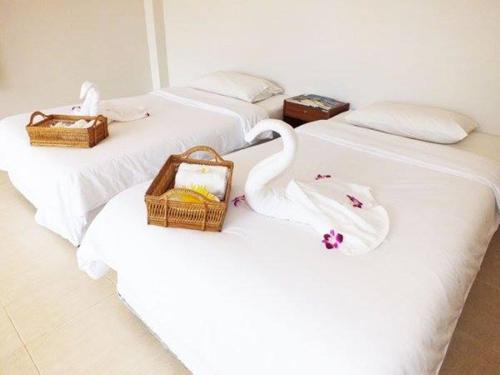 três cisnes brancos estão sentados em duas camas em HaadSon Resort em Bang Saphan Noi