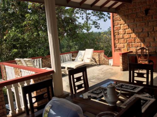 un patio con mesa y sillas en un porche en Kurumba Hills, en Bentota