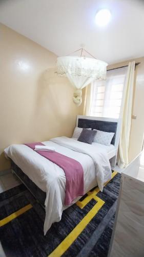 a bedroom with a large bed with a chandelier at Unique place Studio Thika in Thika