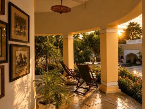 a porch with two chairs and a potted plant at AM Hotel Kollection- Maangarh, Ratlam in Sailāna