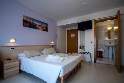 ein Schlafzimmer mit einem großen weißen Bett in einem Zimmer in der Unterkunft Hotel Eliani in Grado