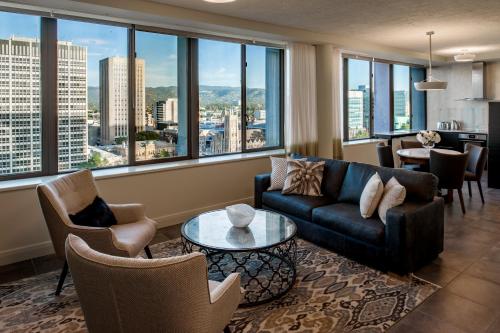 a living room with a couch and chairs and windows at Suite 11 Victoria Square in Adelaide