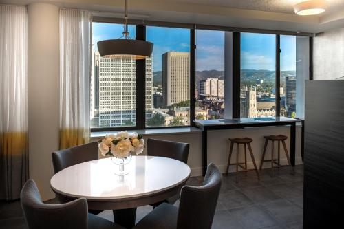 een eetkamer met een tafel en stoelen en een groot raam bij Suite 11 Victoria Square in Adelaide