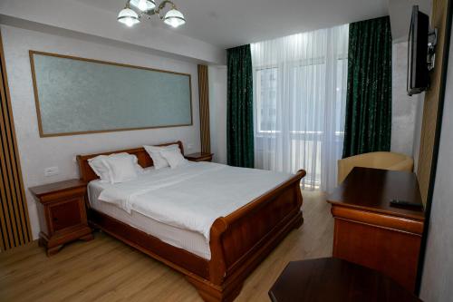 a bedroom with a bed and a large window at Hotel Senator in Slatina
