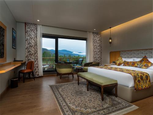 a hotel room with a bed and a large window at Mountnoor Sarovar Premiere Pahalgam in Anantnāg