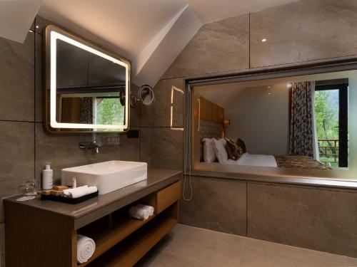 a bathroom with a sink and a large mirror at Mountnoor Sarovar Premiere Pahalgam in Anantnāg