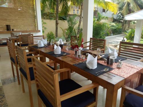 a dining room with a long wooden table and chairs at Sky and Sand Guesthouse in Beruwala