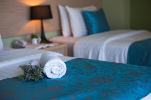 a towel on a bed in a hotel room at Thipurai City Hotel in Hua Hin