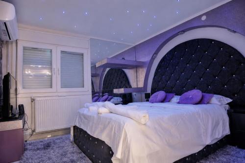 a bedroom with a large bed with an arch overhead at Eleni De Lux - Indoor Jacuzzi Residence in Lydia in Lidia