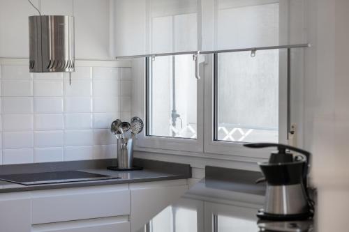 a white kitchen with a window and a sink at Apartamento Platas Centro in Ribadesella