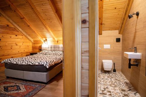 a bedroom with a bed in a wooden cabin at Lika View house in Gospić