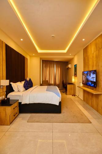 a bedroom with a bed and a flat screen tv at Vintano Hotel in Lagos