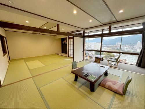 a living room with a table and a large window at Bosenkan in Gero