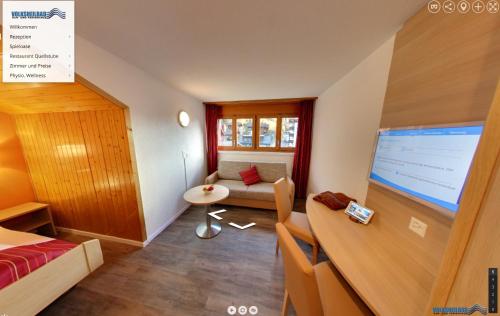 a room with a living room with a large screen at Therme 51° Hotel Physio & Spa in Leukerbad