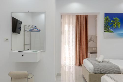 a white bedroom with a bed and a window at Ksamil Guesthouse Villa in Ksamil