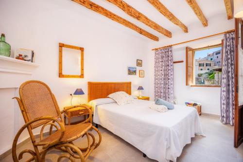 a bedroom with two beds and a chair and a window at Ca Sa Padrina Banyalbufar in Banyalbufar