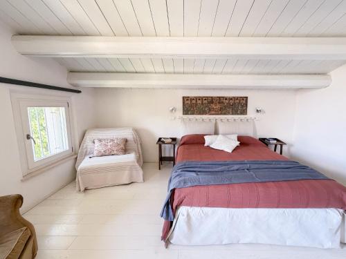a bedroom with a bed and a chair at Borgoparvo Countryvilla in Sirolo