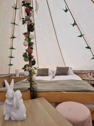 a room with a bed with a tree with flowers at Chill Glamping in Corbu