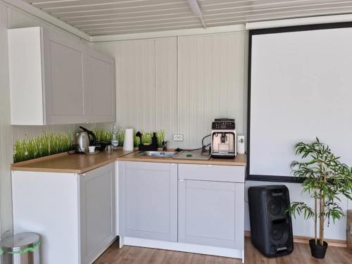a kitchen with white cabinets and a microwave at Chill Glamping in Corbu