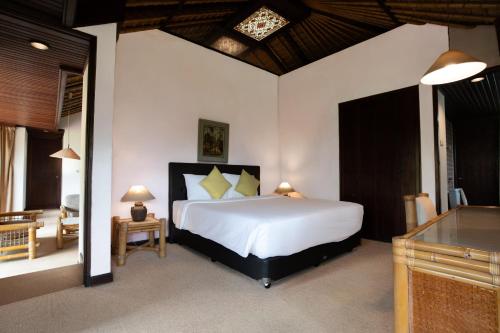 a bedroom with a large white bed and a desk at The Buyan Resort Bedugul in Bedugul