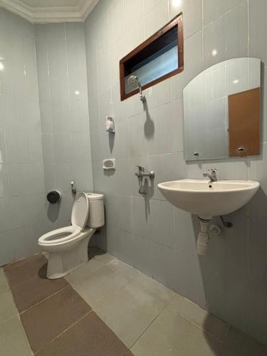 a bathroom with a toilet and a sink at Hotel Prima Asri 153 in Batu