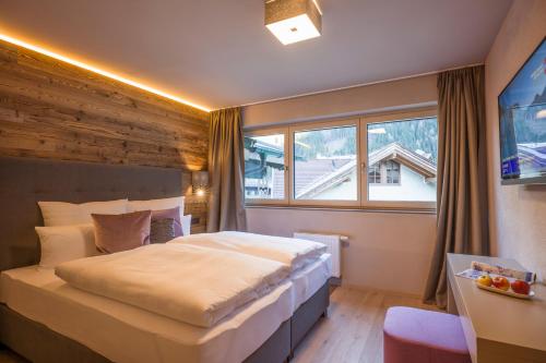 a bedroom with a large bed and a window at Postresidenz in Mayrhofen