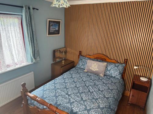 a bedroom with a bed with a blue comforter at Hannah's Cottage in Farranfore
