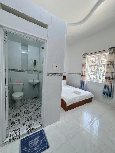 a bathroom with a bed and a toilet and a sink at Ngoc May Guesthouse in Chau Doc