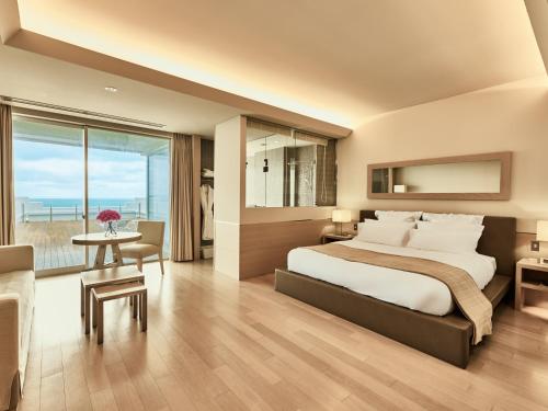 a bedroom with a large bed and a table with a desk at Hotel Greges in Munakata