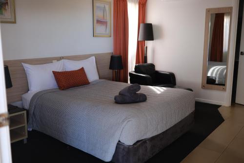 a hotel room with a bed with a stuffed animal on it at Cobar Central Motor Inn in Cobar