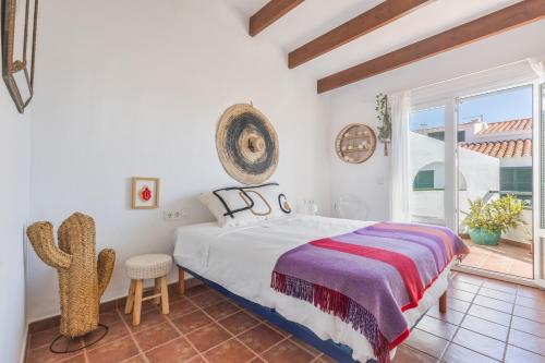 a bedroom with a bed and a large window at Villa Sol del Este, Es Castell in Es Castell