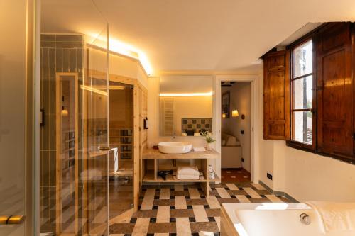 ein Badezimmer mit Waschbecken und Glasdusche in der Unterkunft Borgo San Luigi in Monteriggioni